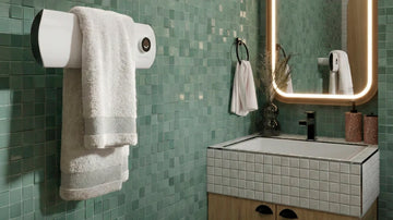 Banheiro moderno com revestimento cinza, banheira branca, bancada em madeira e toalheiro preto vertical ao lado do espelho iluminado